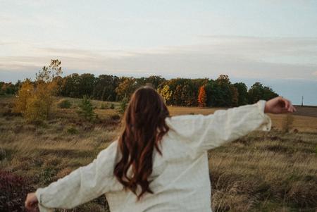 Mulher em um campo aberto, representando liberdade e bem-estar
